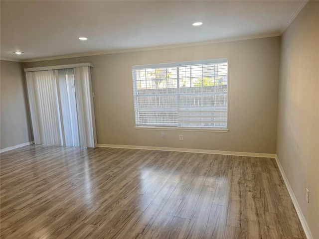 spare room featuring ornamental molding and light wood-type flooring