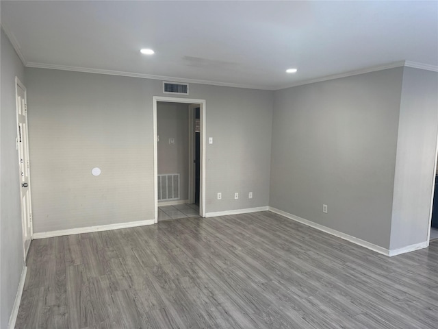 spare room featuring wood-type flooring and ornamental molding