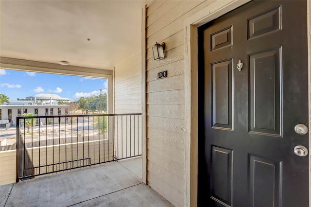 view of exterior entry with a balcony