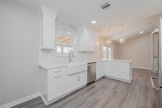 kitchen featuring white cabinetry, sink, hanging light fixtures, kitchen peninsula, and stainless steel appliances