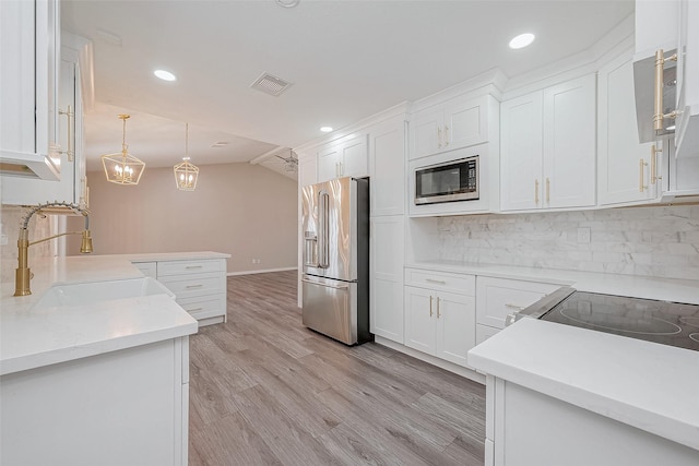 kitchen with sink, white cabinetry, decorative light fixtures, stainless steel appliances, and decorative backsplash