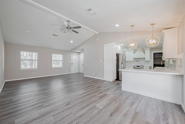 kitchen featuring sink, appliances with stainless steel finishes, light hardwood / wood-style floors, white cabinets, and decorative light fixtures