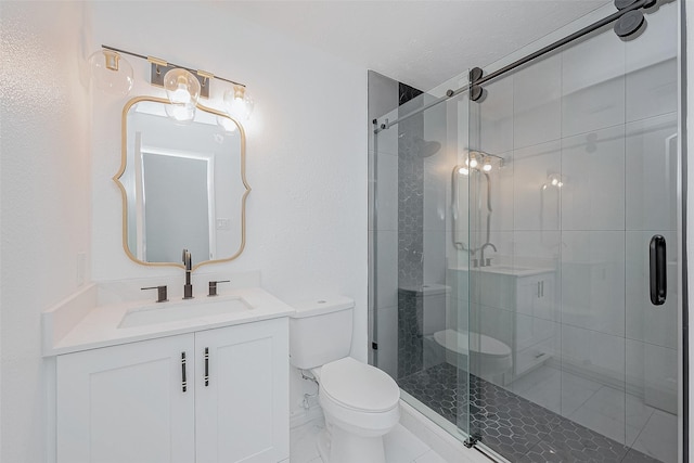 bathroom featuring vanity, a shower with shower door, and toilet