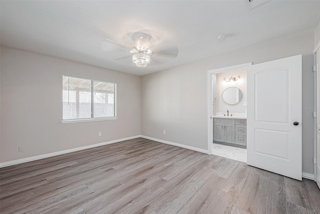 unfurnished bedroom featuring connected bathroom, light hardwood / wood-style flooring, and ceiling fan