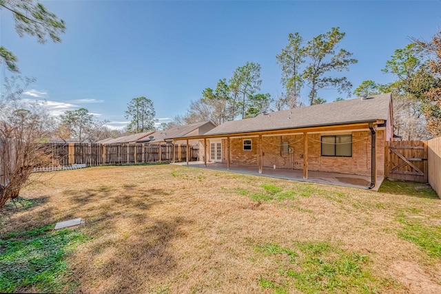 back of property with a yard and a patio