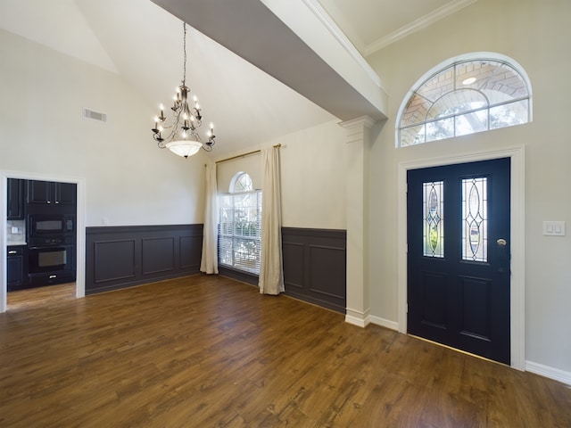 entrance foyer featuring ornamental molding, high vaulted ceiling, a chandelier, and dark hardwood / wood-style flooring