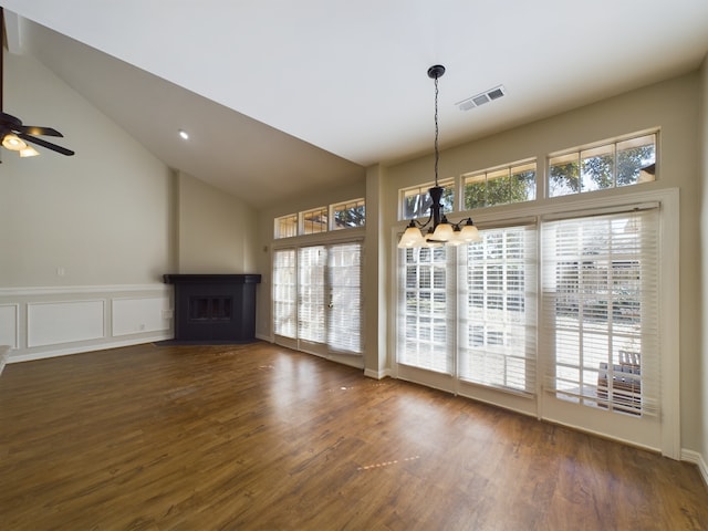 unfurnished dining area with high vaulted ceiling, dark hardwood / wood-style flooring, and ceiling fan with notable chandelier