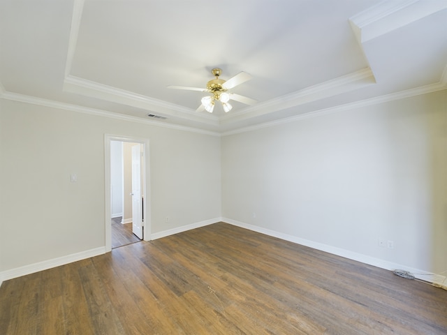 spare room with ceiling fan, ornamental molding, dark hardwood / wood-style floors, and a tray ceiling