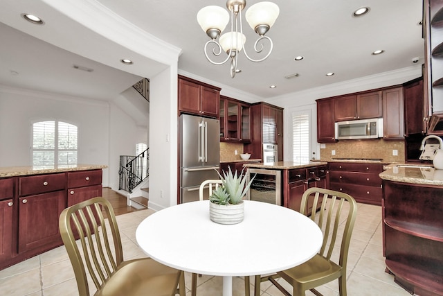 dining room featuring wine cooler, ornamental molding, an inviting chandelier, and sink