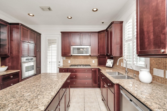 kitchen featuring sink, light tile patterned floors, ornamental molding, stainless steel appliances, and light stone countertops