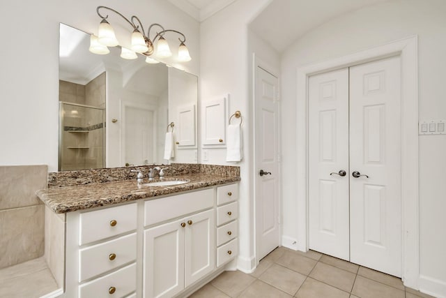 bathroom featuring tile patterned flooring, vanity, ornamental molding, and walk in shower