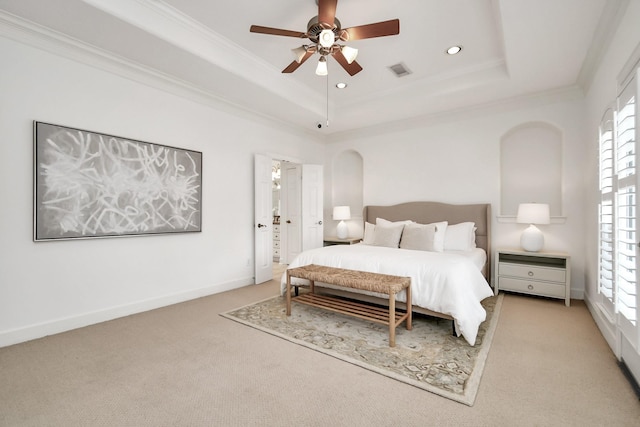 carpeted bedroom with multiple windows, ornamental molding, and a tray ceiling