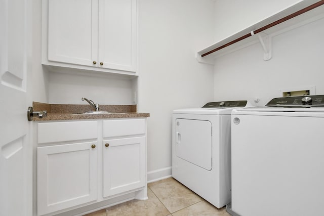 washroom with cabinets, independent washer and dryer, sink, and light tile patterned floors