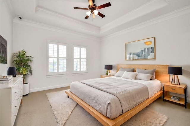 bedroom with a tray ceiling, carpet floors, and ornamental molding