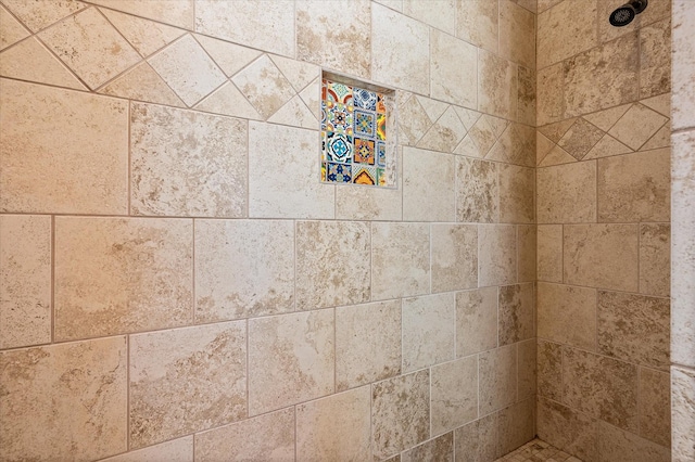 interior details featuring a tile shower