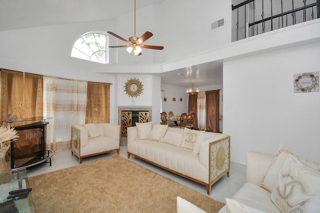 living room featuring ceiling fan with notable chandelier and high vaulted ceiling