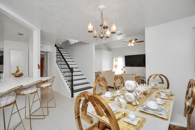 dining room with lofted ceiling, ceiling fan with notable chandelier, and a textured ceiling