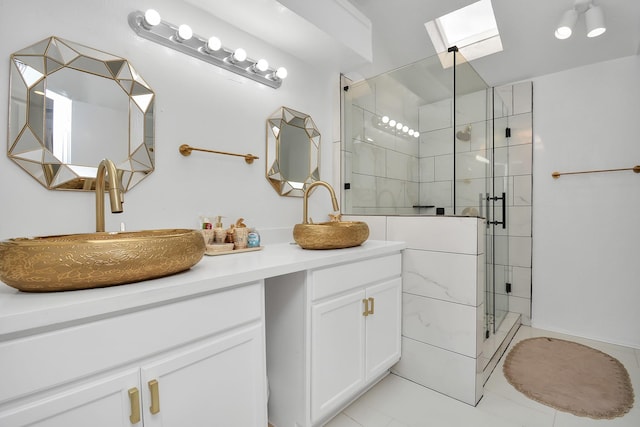 bathroom with vanity, a skylight, and a shower with shower door