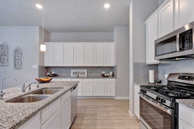 kitchen featuring pendant lighting, white cabinetry, appliances with stainless steel finishes, and sink