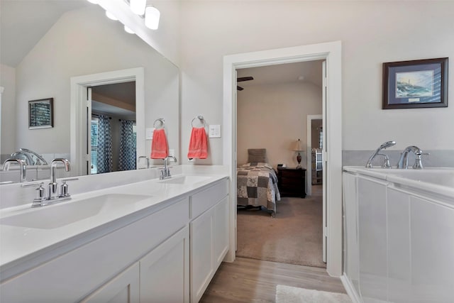 bathroom featuring vanity, vaulted ceiling, and hardwood / wood-style floors