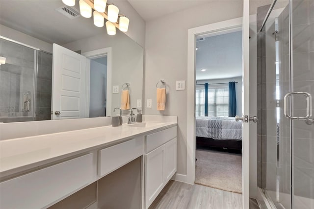 bathroom featuring hardwood / wood-style flooring, vanity, and a shower with shower door