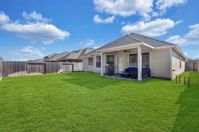 rear view of house with ceiling fan, an outdoor living space, a patio area, and a lawn