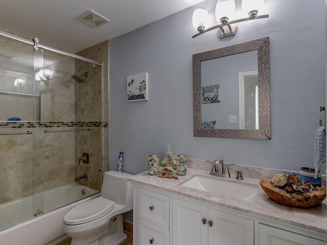 full bathroom featuring vanity, shower / bath combination with glass door, and toilet