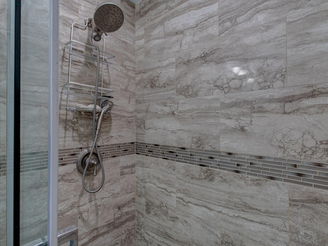 interior details featuring a tile shower