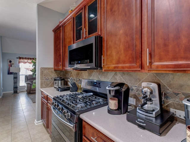 kitchen with tasteful backsplash, stainless steel appliances, and light tile patterned flooring