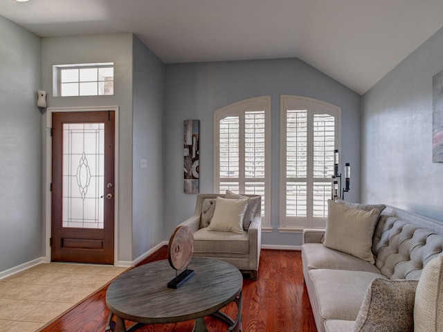 entrance foyer with hardwood / wood-style floors and vaulted ceiling