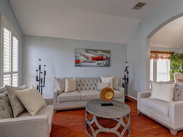 living room featuring wood-type flooring and vaulted ceiling