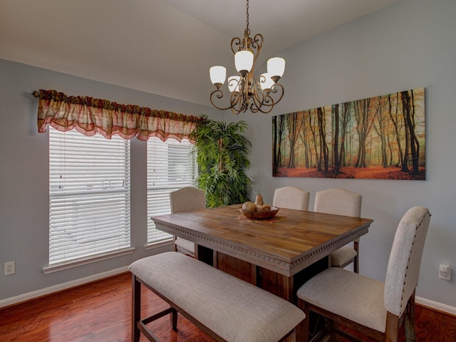 dining room with lofted ceiling, hardwood / wood-style floors, and a chandelier