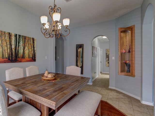 tiled dining area featuring an inviting chandelier