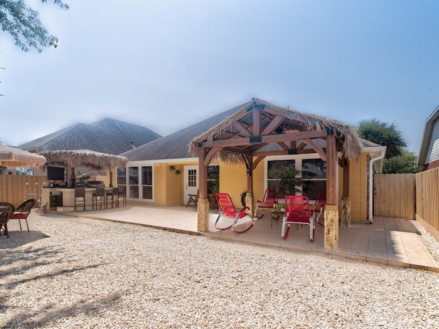 rear view of house with a gazebo, a patio, and an outdoor bar