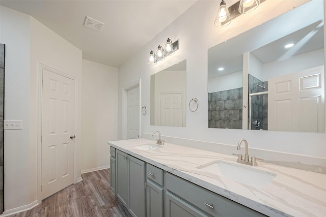 bathroom featuring hardwood / wood-style flooring, vanity, and walk in shower