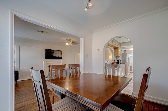 dining area with hardwood / wood-style floors, crown molding, and ceiling fan