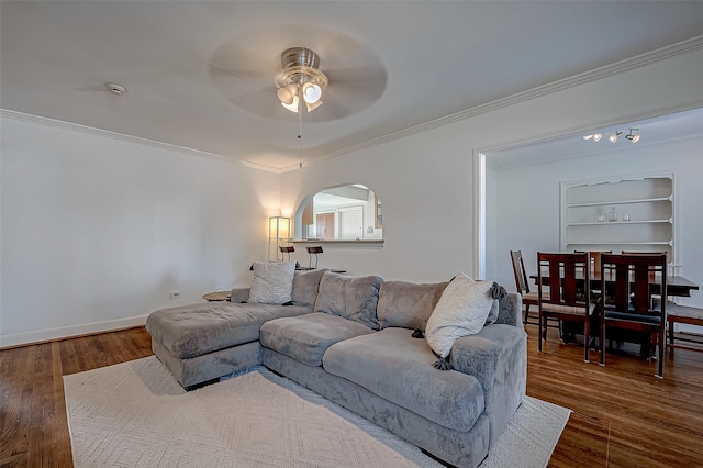 living room featuring ornamental molding, dark hardwood / wood-style floors, built in features, and ceiling fan