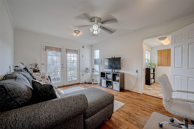 living room with french doors, plenty of natural light, crown molding, and light wood-type flooring