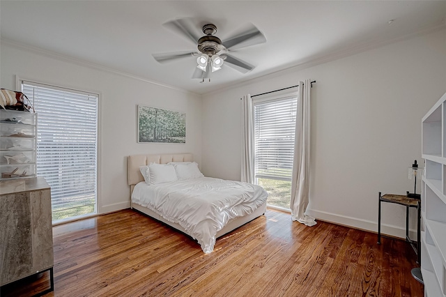 bedroom with hardwood / wood-style flooring, ornamental molding, and ceiling fan