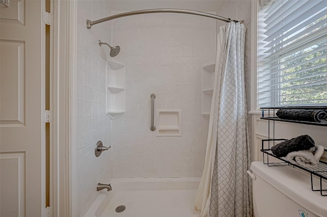 bathroom with curtained shower and toilet