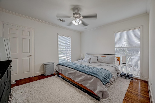 bedroom featuring dark wood-type flooring, ceiling fan, and crown molding