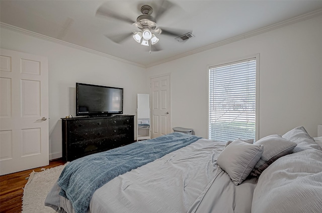 bedroom with ornamental molding, dark wood-type flooring, and ceiling fan