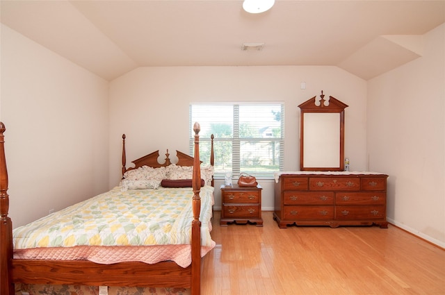 bedroom with vaulted ceiling and light hardwood / wood-style flooring