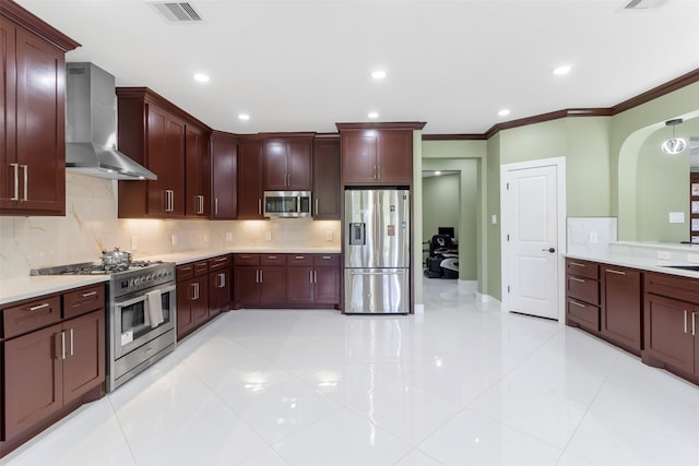 kitchen with appliances with stainless steel finishes, decorative backsplash, ornamental molding, light tile patterned floors, and wall chimney exhaust hood