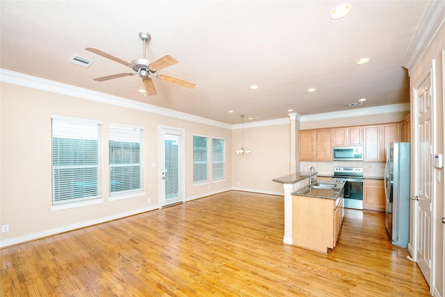 kitchen featuring sink, crown molding, stainless steel appliances, and a center island with sink