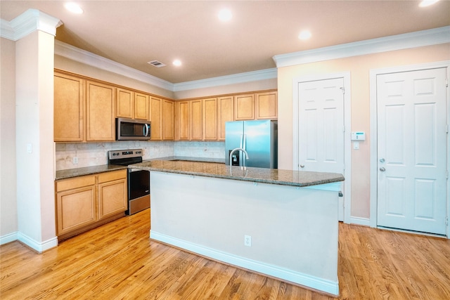 kitchen with light hardwood / wood-style floors, crown molding, stainless steel appliances, and an island with sink