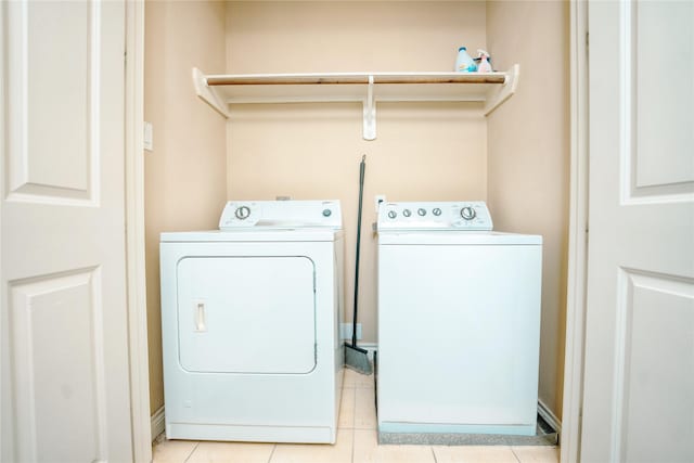 washroom with washer and dryer and light tile patterned floors