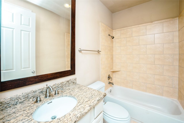 full bathroom with tiled shower / bath, vanity, and toilet