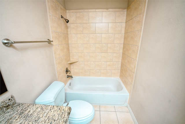 bathroom with tile patterned flooring, tiled shower / bath, and toilet