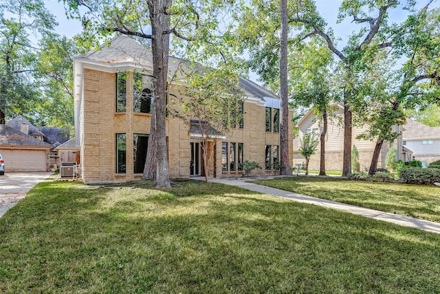 view of front of home featuring a garage, central AC, and a front yard